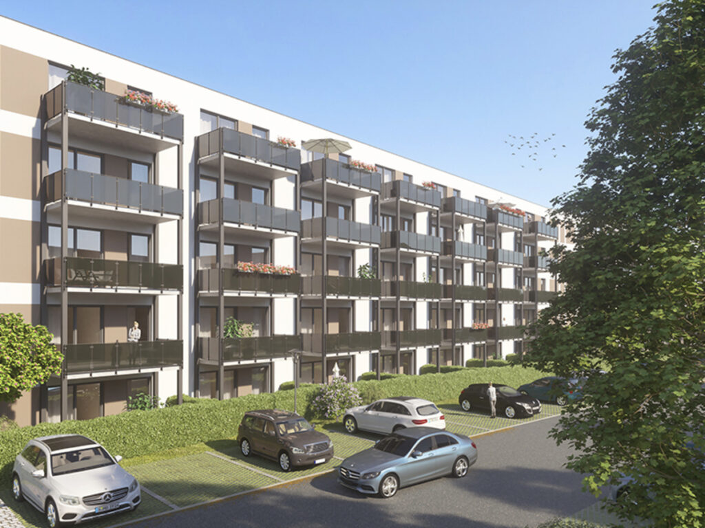 Mehrfamilienhaus mit Balkonen, davor parkende Autos.