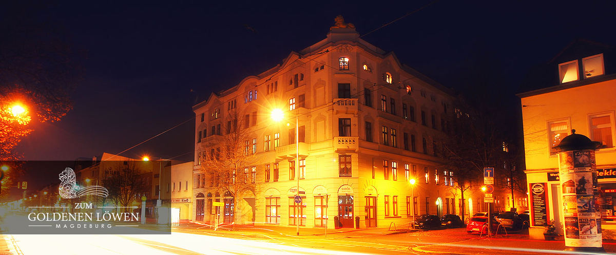 Nachts beleuchtetes Gebäude an einer Straßenecke.