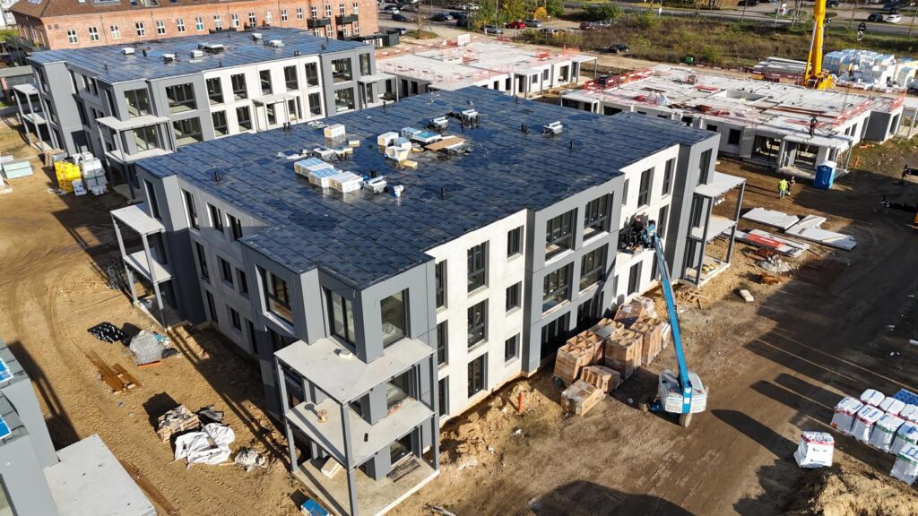 Moderne Wohngebäude im Bau mit Baustellenaktivität.